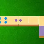 Pllaka dominoje me pika shumëngjyrëshe të vendosura mbi një sfond të gjelbër