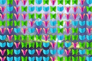 Flutura shumëngjyrëshe të organizuara në rreshta mbi një sfond me peizazh natyror