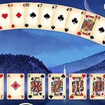 Një përzierje e letrave të pokerit me sfond malor dhe qiell të ndriçuar nga hëna