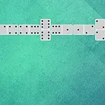 Domino të radhitura në një formë zigzag mbi një sfond të gjelbër