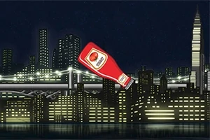 Shishe ketchup-i në sfondin e një qyteti me ndërtesa dhe ura të ndriçuara gjatë natës