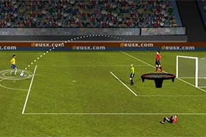 Një lojtar futbolli godet një top drejt portës, ndërsa një lojtar në një platformë qëndron pranë portës dhe një tifoz është në tribunë