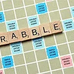 Gjithsejta me shkronja prej druri që formojnë fjalën SCRABBLE mbi një tabelë loje të ndarë në katrorë me ngjyra të ndryshme që tregojnë pikë të trefishta dhe të dyfishta