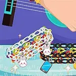 Një dorë që luan kitarë, me dy byzylykë të zinxhirë shumëngjyrësh të dekoruar me figura lepurushi, një telefon dhe një hënë