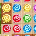Karamele me ngjyra të ndryshme në formë spiraleje të vendosura në rreshta dhe kolona në një sfond me kuadrate