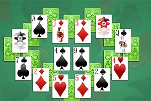 Një grup letrash lojë me figura dhe numra të ndryshëm, të vendosura në një formacion të veçantë mbi një sfond jeshil