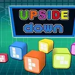 Kubë shumëngjyrëshe me modele të bardha dhe tabela me tekstin Upside Down në sfond