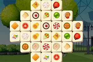 Pamje e një puzzle me pllaka që përmbajnë imazhe ushqimesh të ndryshme si ëmbëlsira dhe fruta, në sfond një park me pemë